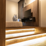Bedroom with a raised timber platform lit by LED strips