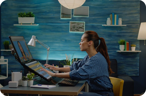 Designer working on a computer with a drawing tablet in a creative studio