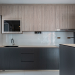 Modern kitchen with timber-look upper cabinets, dark grey lower cabinets, a built-in oven and a white wave-tile backsplash