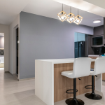 Open kitchen with a white-top island, timber base, bar stools and pendant lights
