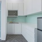 Kitchen with white cabinets and a mint green backsplash