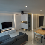 Living and dining area with a TV feature wall and grey sofa