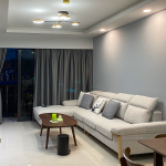 Living room with a grey L-shaped sofa and a timber coffee table