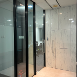 Office entrance with glass doors and marble-look wall panels