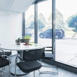 Meeting corner with a round table and chairs by full-height glass windows