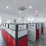 Open-plan office with red and grey workstation partitions