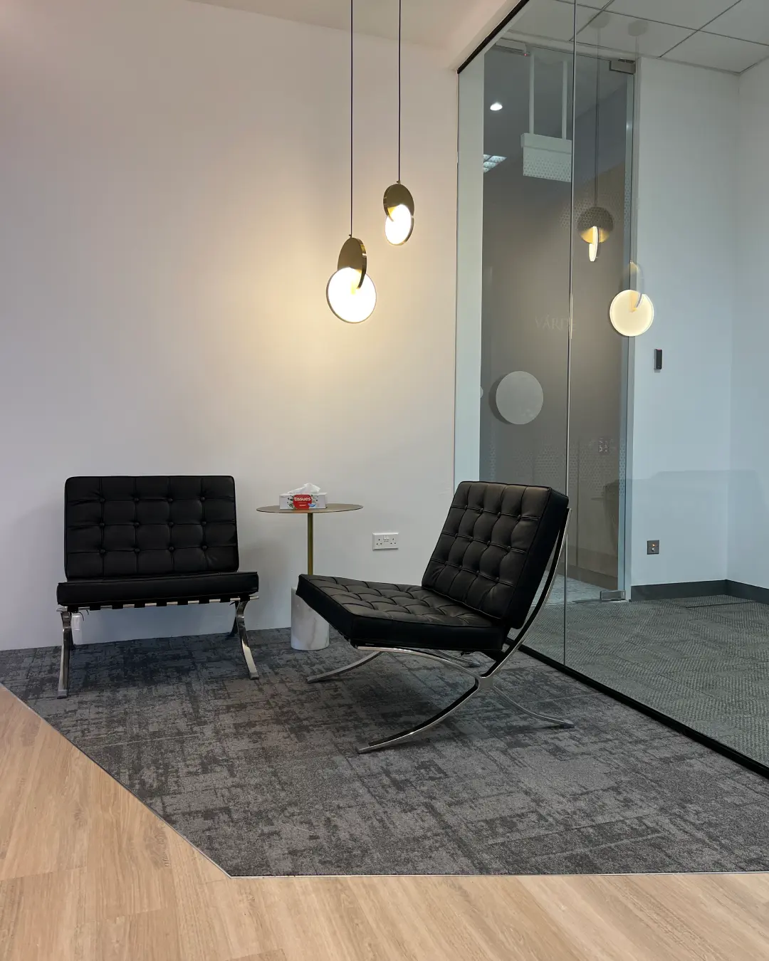 Modern open-plan office fit-out with white workstations, black chairs and planter dividers