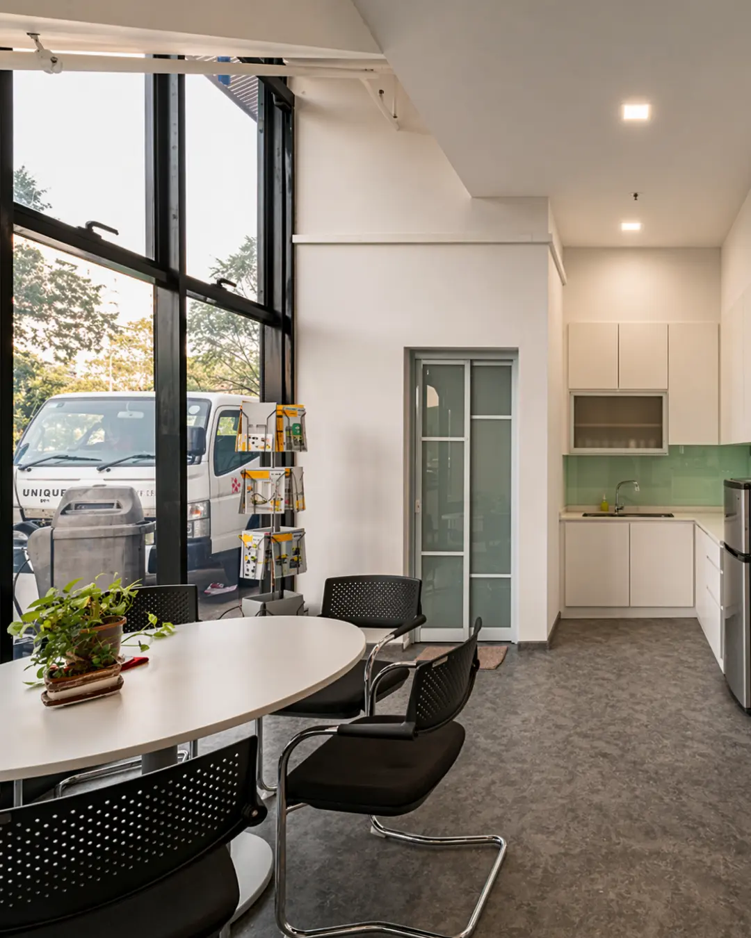 Modern open-plan office fit-out with white workstations, black chairs and planter dividers