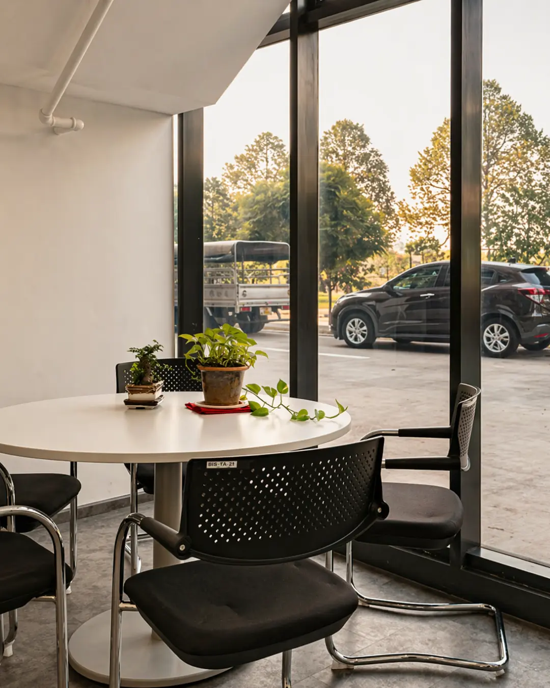 Modern open-plan office fit-out with white workstations, black chairs and planter dividers