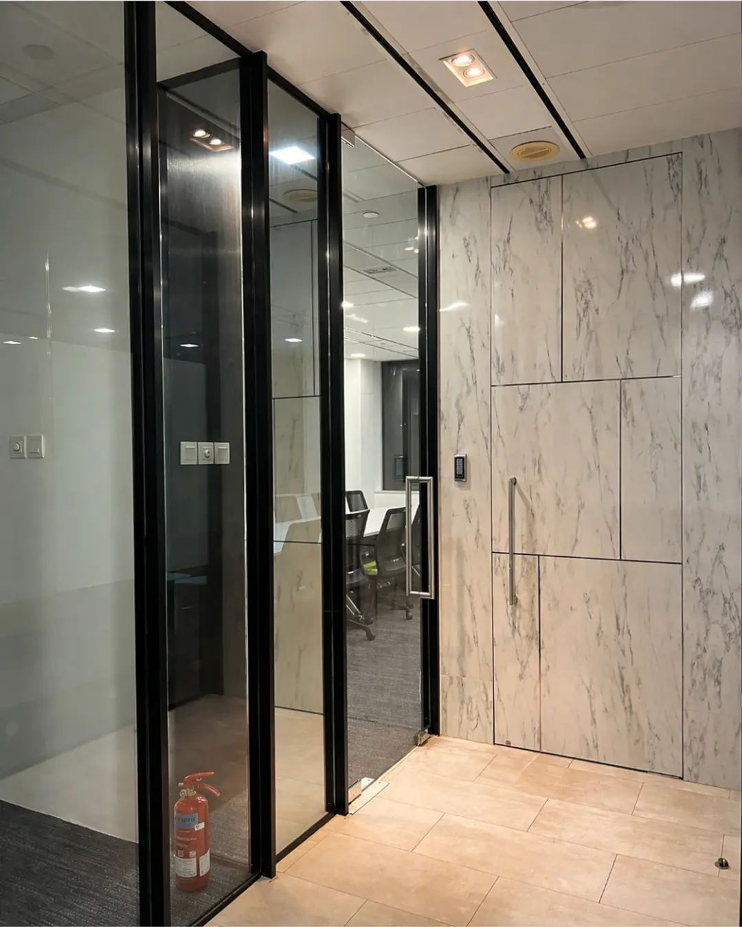 Modern open-plan office fit-out with white workstations, black chairs and planter dividers