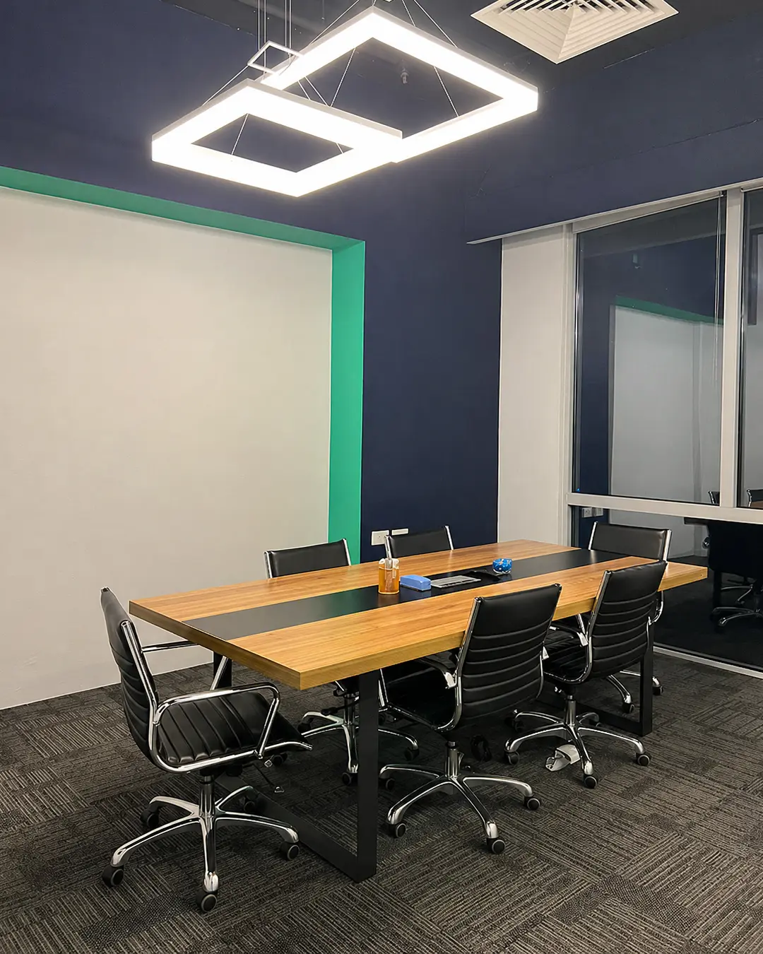 Modern open-plan office fit-out with white workstations, black chairs and planter dividers
